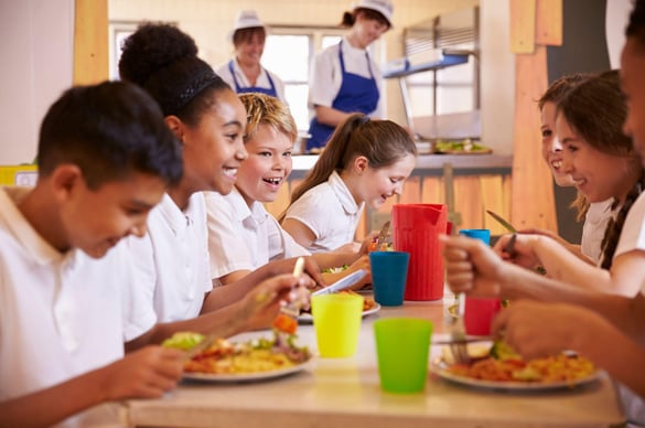 Primary school kids eat lunch in school